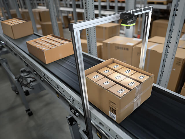 Conveyor belt with fixed barcode scanning system in warehouse