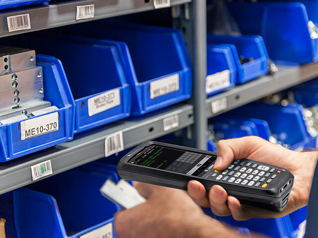 Worker using barcode scanner in warehouse inventory system