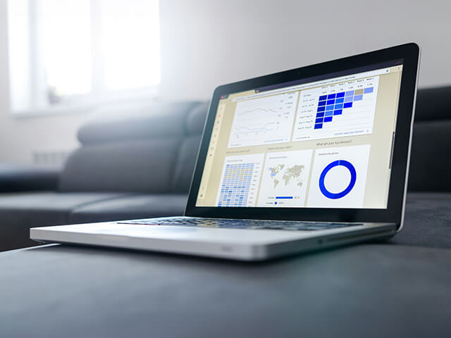 Open laptop displaying industrial data dashboards and analytics